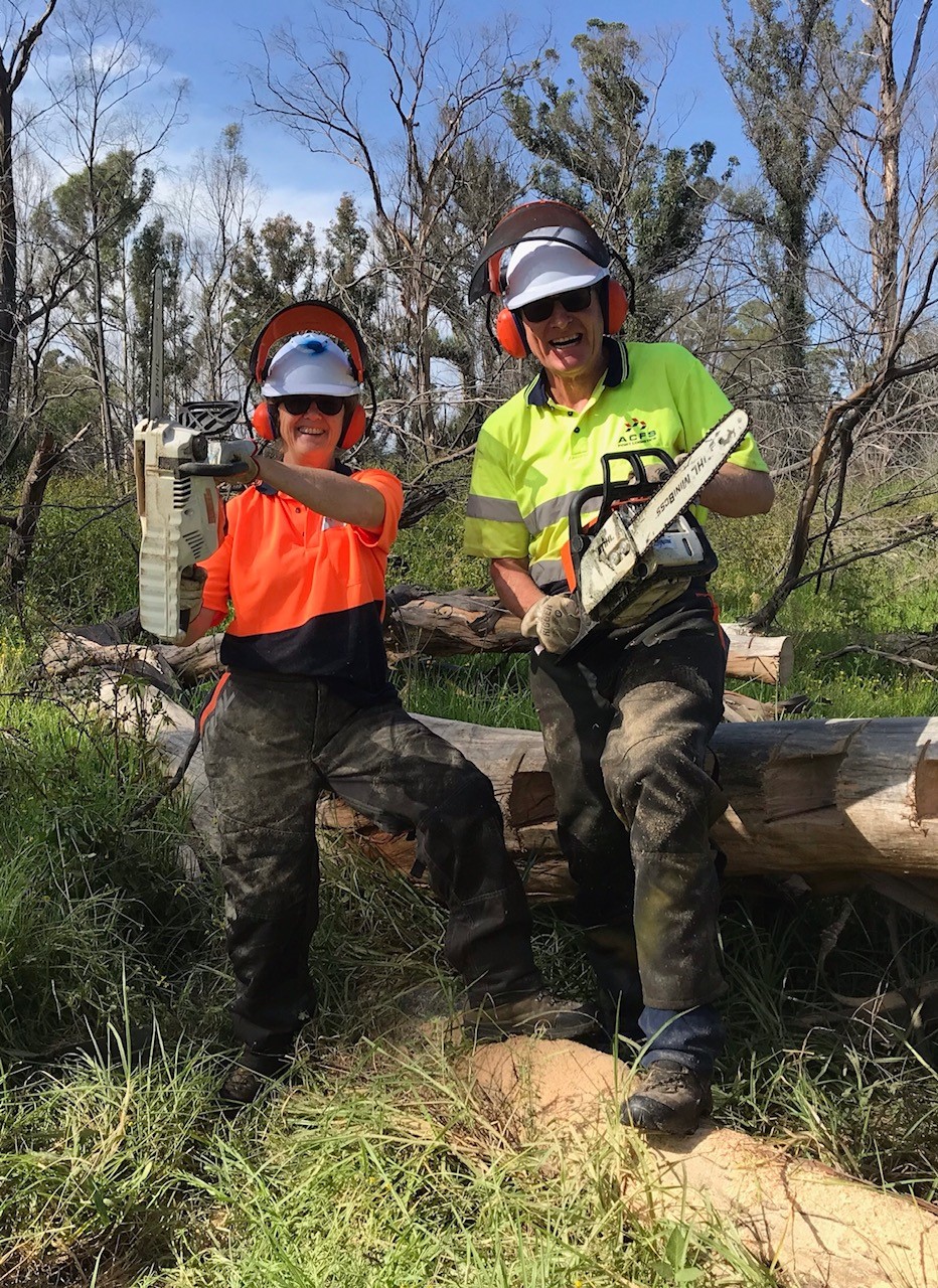 Glenn Dobson with wife Ann both holding chainsaws for BlazeAid Volunteering