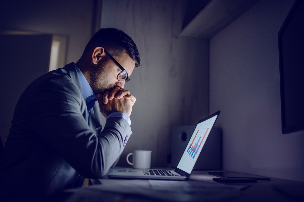 man at laptop in a suite mental health in sales awareness